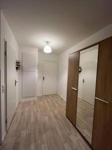 um quarto vazio com um corredor com pisos em madeira e uma porta em Paris- Disney - Parking privé !PKN! em Torcy