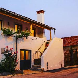 a white house with a stairway leading to a door at CASA ANDORINHAS in Fontainhas