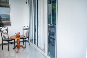 a room with a table and chairs on a balcony at Sky Edge Homestay in Kandy