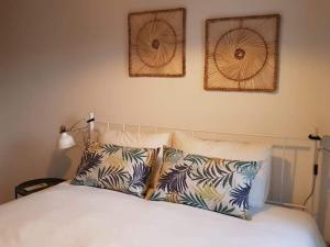 a bedroom with a bed with three pictures on the wall at CASA ANDORINHAS in Fontainhas