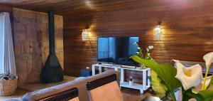 sala de estar con TV de pantalla plana y chimenea en Summer Villa, en Mossel Bay