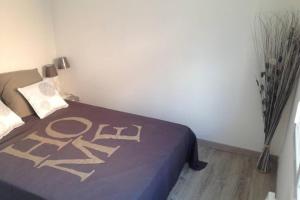a bedroom with a bed with a purple blanket with the word raid on it at Les Logis du Petit Prince in La Teste-de-Buch