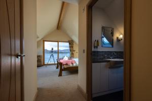 Shore Cottage Isle of Skye في بورتري: حمام مع مغسلة وسرير في الغرفة