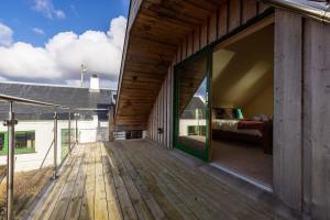 een houten terras met een slaapkamer en een bed bij Shore Cottage Isle of Skye in Portree