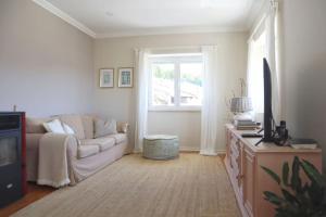 ein Wohnzimmer mit einem Sofa und einem Fenster in der Unterkunft Casal de São José - Modern Country House in Mafra