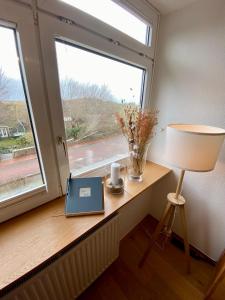 ein Laptop auf einem Tisch neben einem Fenster in der Unterkunft Ferienwohnung Uttied in Baltrum