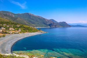 a view of a beach with the ocean and mountains at LOCATION CORSE in Canari
