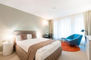 1 dormitorio con 1 cama grande y 1 silla azul en Studiohouse Frankfurt en Frankfurt