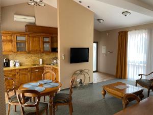 a kitchen and a living room with a table and a dining room at Apartment Senamiesčio Inkaras in Klaipėda