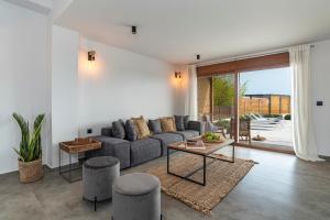 a living room with a couch and a table at Luxury NissoVilla with Private Pool & Sea Views in Kolimbia