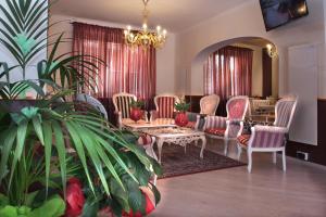 un soggiorno con sedie, tavolo e piante di Hotel Due Spade a Fidenza