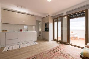 a kitchen with white cabinets and a view of the ocean at Casa Alvar - Califa Casas Vejer in Vejer de la Frontera