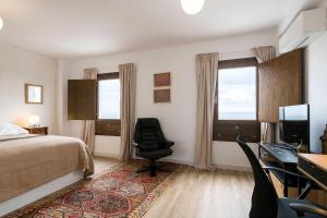 a bedroom with a bed and a desk and a chair at Casa Alvar - Califa Casas Vejer in Vejer de la Frontera