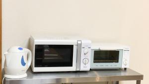a microwave and a toaster oven sitting on a counter at Guesthouse Kyoto Abiya in Kyoto
