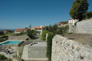 uma casa com uma parede de pedra e uma piscina em INATEL Linhares da Beira Hotel Rural em Linhares