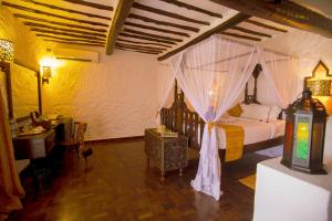 a bedroom with a bed with a canopy at Zanzibar Beach Resort in Zanzibar City