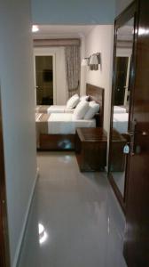 アレクサンドリアにあるAbeer Hotel Alexandriaのベッドと鏡が備わるホテルルーム