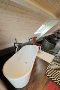 eine weiße Badewanne in einem Zimmer mit einer Decke in der Unterkunft Chambre d'hôtes Boutteville in Boutteville