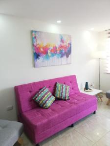 un sofá púrpura con 2 almohadas en la sala de estar en Casabella Salento familias en Salento