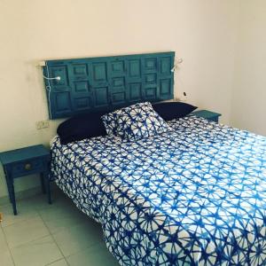 1 dormitorio con 1 cama con edredón azul y blanco en El Raconet de Dénia, en Denia