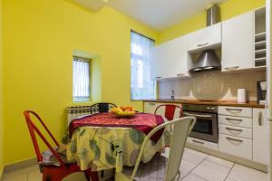 a kitchen with a table with a bowl of fruit on it at Quattro Cantoni Apartments in Zadar