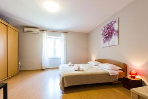 a bedroom with a bed with two stuffed animals on it at Quattro Cantoni Apartments in Zadar