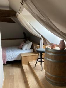 - une chambre avec un lit et un tonneau dans l'établissement Le Moulin De Bretigneul, à Saint-Aubin-des-Landes