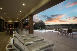 a patio with chairs and a table and a sunset at Buffalo Brooke in Hectorspruit