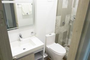 a bathroom with a toilet and a sink and a shower at Hotel Wayra Club in Acacías +42 photos