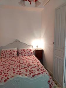 um quarto com uma cama com um edredão vermelho e branco em LA CASA DEL SOL em Pego