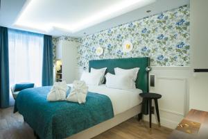 فندق كامبون في باريس: غرفة نوم مع سرير وورق جدران زرقاء