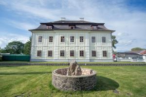 a large white building with a statue in front of it at Chateau Diva in Turčianske Teplice