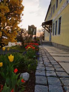 una pasarela de piedra frente a un edificio con flores en Hotel-Restaurant Kreuzhuber, en Neuburg am Inn