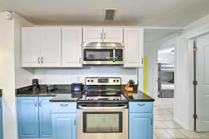 a kitchen with blue cabinets and a microwave at PCB Group Retreat with Deck, 1 Block to Beach! in Panama City Beach