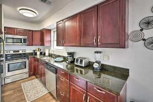 a kitchen with wooden cabinets and a counter top at PCB Group Retreat with Deck, 1 Block to Beach! in Panama City Beach