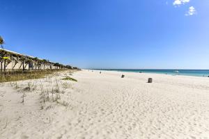 a sandy beach with people in the water and the ocean at PCB Group Retreat with Deck, 1 Block to Beach! in Panama City Beach