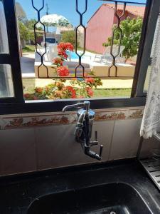 a kitchen sink with a window above it with a sink at Itaipuaçu Residencia Cajueiros I in Itaipuaçu