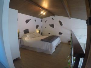a bedroom with a bed and a wall with rocks on it at Casa Tajaraste in Hermigua