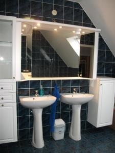 La salle de bains est pourvue de 2 lavabos et d'un grand miroir. dans l'établissement Jóbor Vendégház, à Győrújbarát