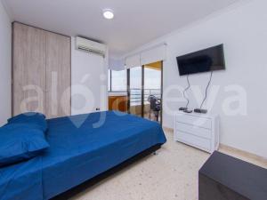 um quarto com uma cama azul e uma televisão de ecrã plano em Apartamento 1 Alcoba en Altamar 703 Cartagena em Cartagena das Índias