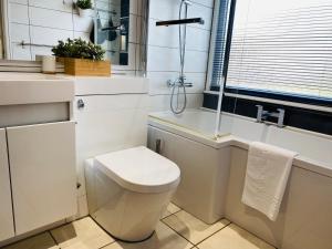 een witte badkamer met toilet en ligbad bij Mayors House Ideal for Groups & Business in Peterborough +38 foto's