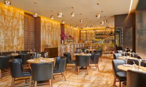 un restaurante con mesas y sillas y un bar en Hotel Cafe Royal, en Londres