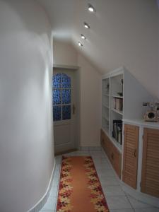 a hallway with an orange rug and a door at Jóbor Vendégház in Győrújbarát