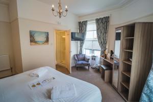 a hotel room with a bed and a desk and a chair at Johnny Dough's Conwy with Rooms in Conwy