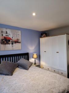 a bedroom with a large bed and a blue wall at Cosy Getaway ! in Kent