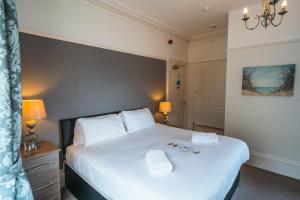 a bedroom with a bed with two towels on it at Johnny Dough's Conwy with Rooms in Conwy
