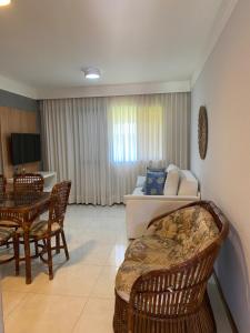 a living room with a couch and a table and chairs at Guarajuba - Genipabu Summer House (Flat beira mar) in Camaçari