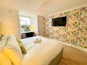 a bedroom with a large bed with a tv on the wall at Elite 3 Bed New Town Apt with Private Walled Garden in Edinburgh