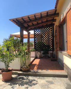 een houten pergola op een huis met planten bij Donna Caterì in Termini