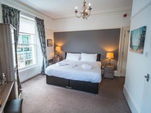 a bedroom with a large white bed and a window at Johnny Dough's Conwy with Rooms in Conwy
